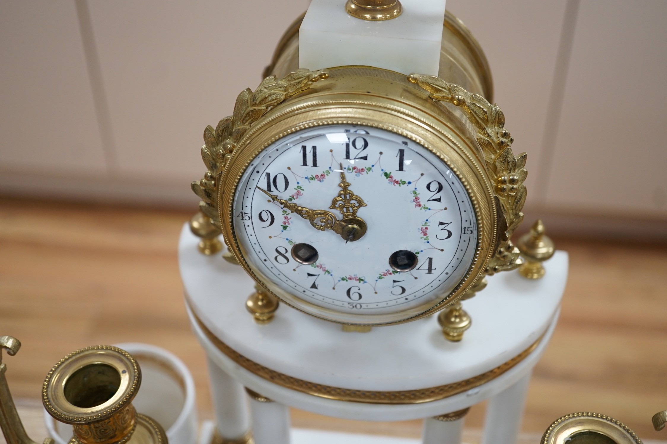 A classical revival white marble and only three-piece clock garniture, early 20th century. 42cm high